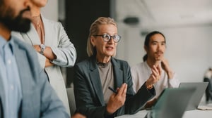 Compliance-Verantwortliche bespricht sich mit Kolleginnen und Kollegen in einem modernen Büro.