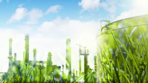 Eine Industrieanlage mit Tanks und Produktionsanlagen ist von grünem Gras umgeben.