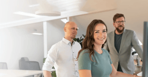 Drei Personen arbeiten gemeinsam am Computer im modernen Büro.