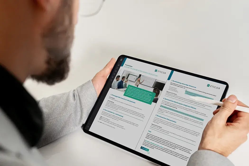 Ein Mann hält ein Tablet und bedient es mit einem Eingabestift. Auf dem Bildschirm ist eine Eticor-Publikation zu sehen.