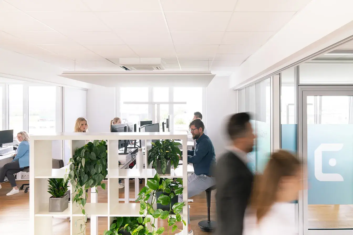 Helles, modernes und lichtdurchflutetes Büro von Eticor mit mehreren Mitarbeitenden an Schreibtischen und Monitoren. Helles, modernes und lichtdurchflutetes Büro von Eticor mit mehreren Mitarbeitenden an Schreibtischen und Monitoren.